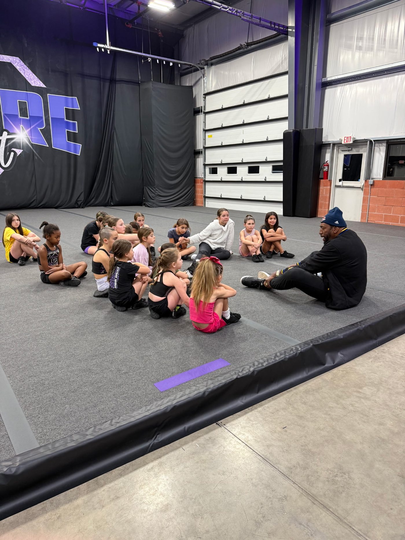 Coach Ray sitting with kids in a circle